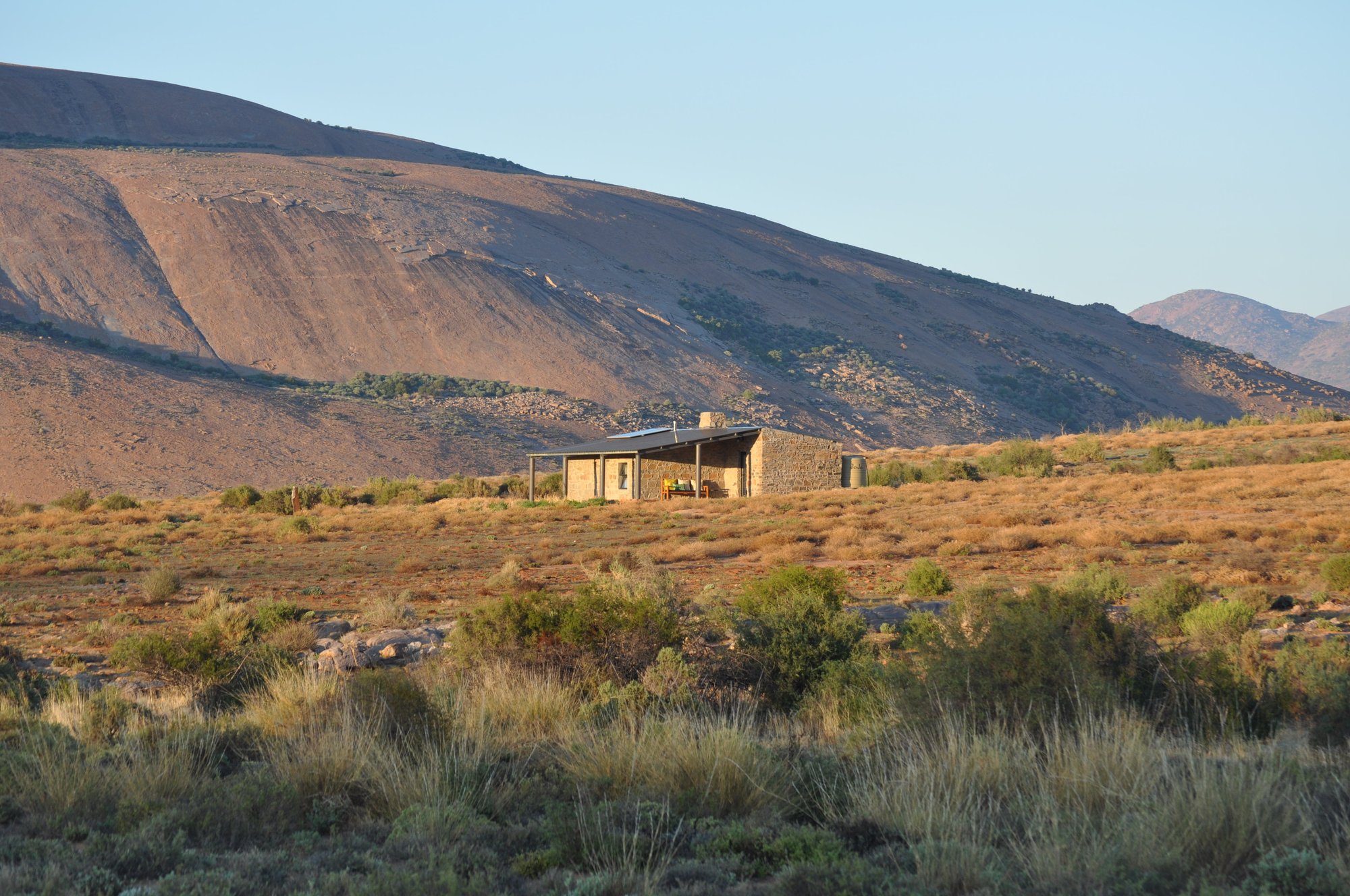 The cottage at sunset with mountains behind